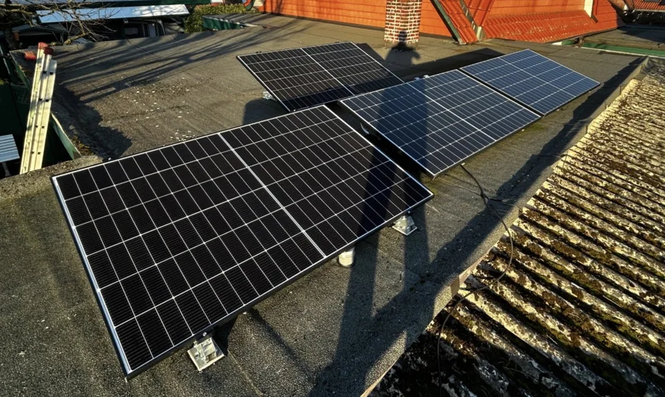Mehrere aufgeständerte Solarmodule auf einem Flachdach.