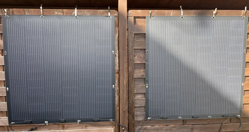 Zwei senkrecht angeordnete Solarmodule mit sichtbaren Befestigungen an einer Holzunterkonstruktion.